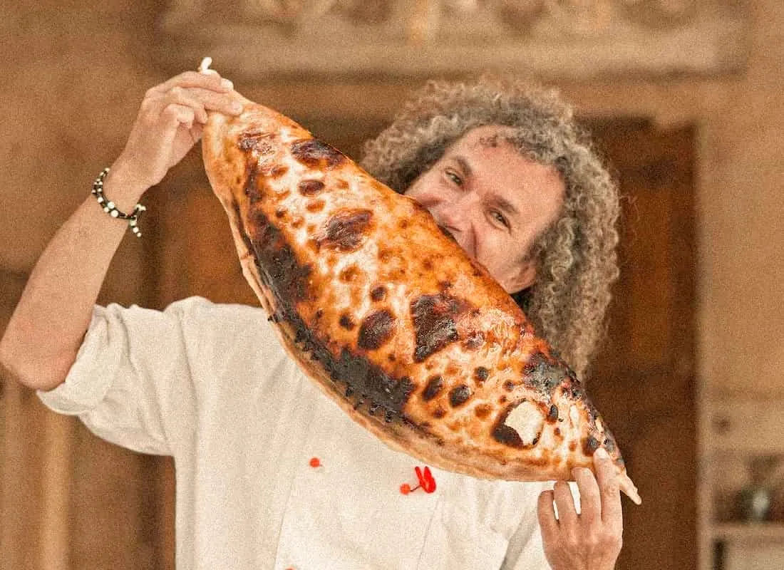 A freshly baked Calzone Dolce held up in the Bandanna kitchen.